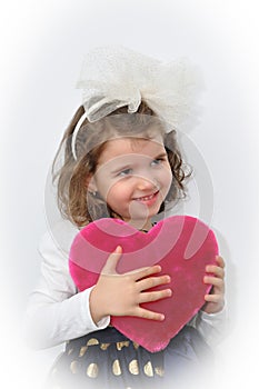 Young girl holding a plush pink heart